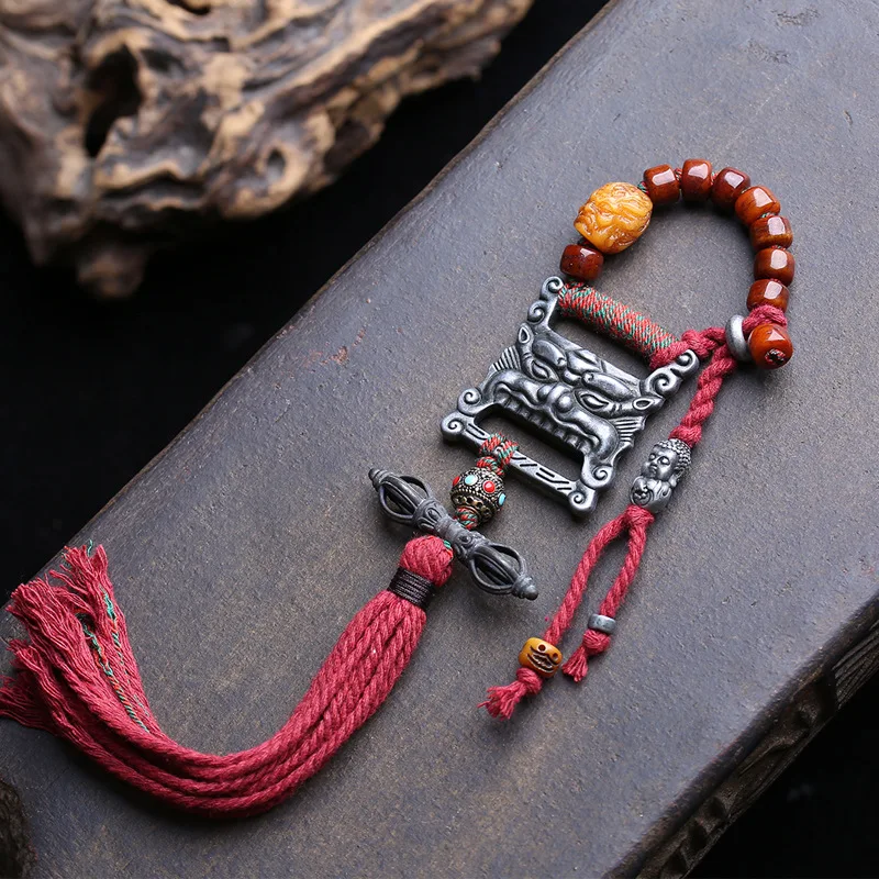Tibetan Buddhist prayer book pendant a snow lion  made from reclaimed bone  with a large black celestial being motif