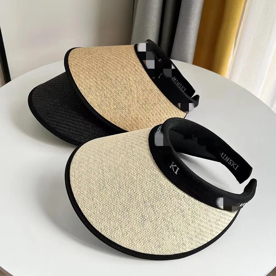 Summer sun hat with black rubber and an empty top. It covers the face and looks small. It is a versatile straw hat