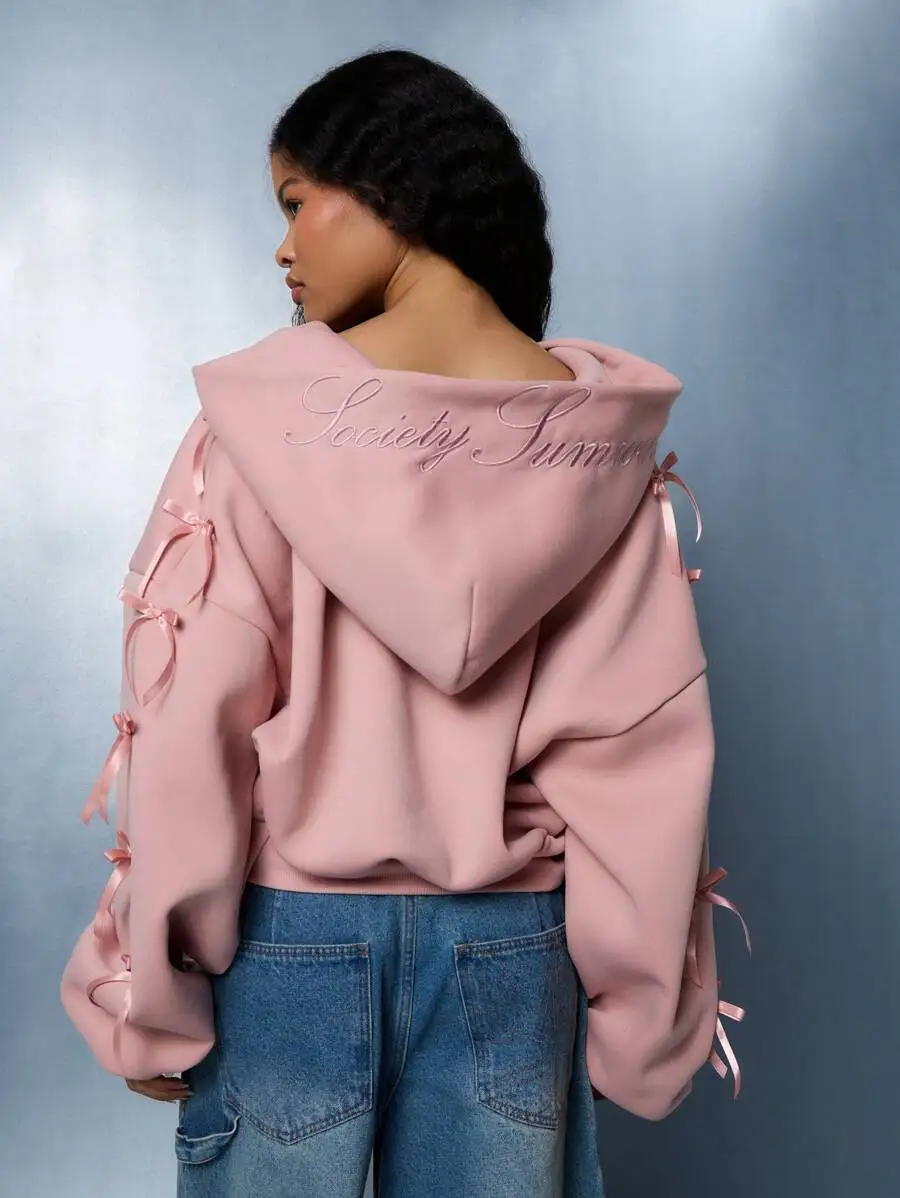 

Розовое укороченное худи на молнии до середины груди с бантом на рукавах и вышивкой на спине