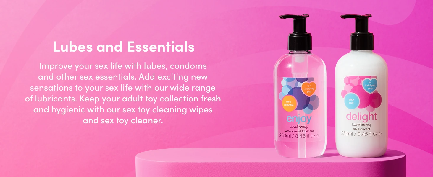Two pink pump bottles of personal care products displayed on a pink platform against a gradient background, with text about lubes and essentials.