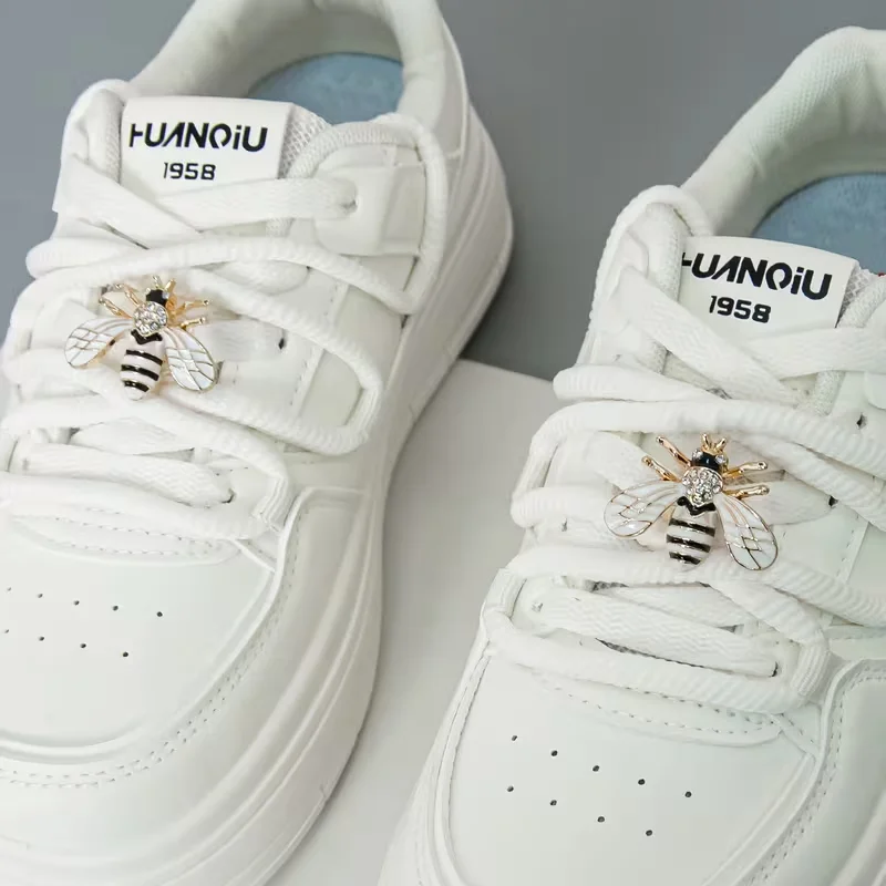 A Pair of Detachable Cute Little Bee-Style White-Winged Shoes with Glittery Decorations on the Laces and the Buckle.