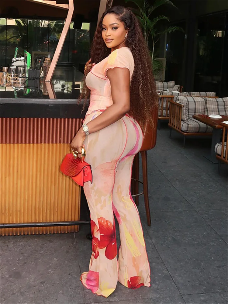 

Стильный комплект из 2 предметов SiSterlinda с цветочным принтом: женский топ с круглым вырезом, асимметричными оборками и разрезом по низу + расклешенные брюки. Элегантный костюм для отпуска.