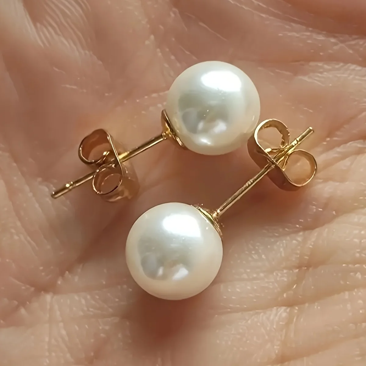 1 pair of stainless steel, round, off-white, pearl-like stud earrings