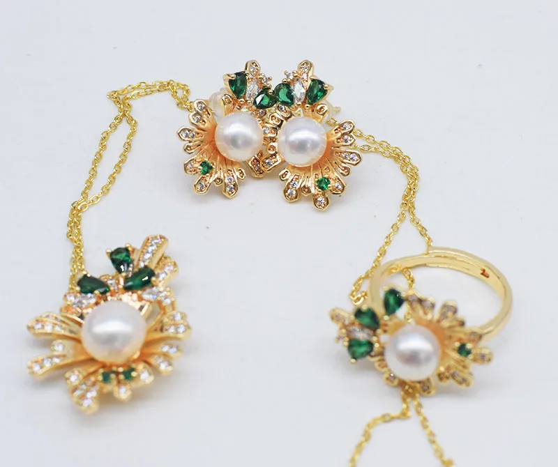 

Набор украшений: кольцо, серьги и подвеска из пресноводного жемчуга белого цвета, с зеленым цирконом в форме цветка.