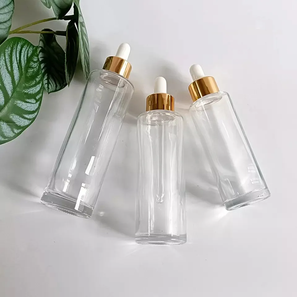 Wholesale 20-100ml Transparent Flat Shoulder Glass Essential Oil Serum Dropper Bottle With Gold Lid Skin Care Emulsion Container