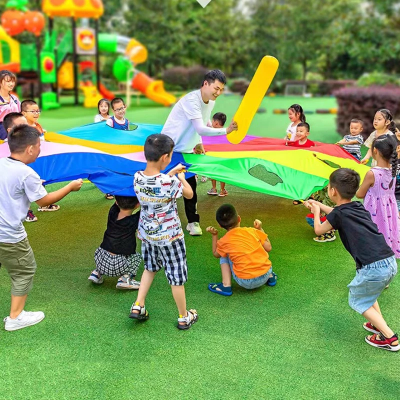 I bambini all'aperto giocano con la tenda del giocattolo dell'arcobaleno del paracadute giochi per bambini parco giochi per l'asilo divertimento delle attività di Team Building della cooperazione