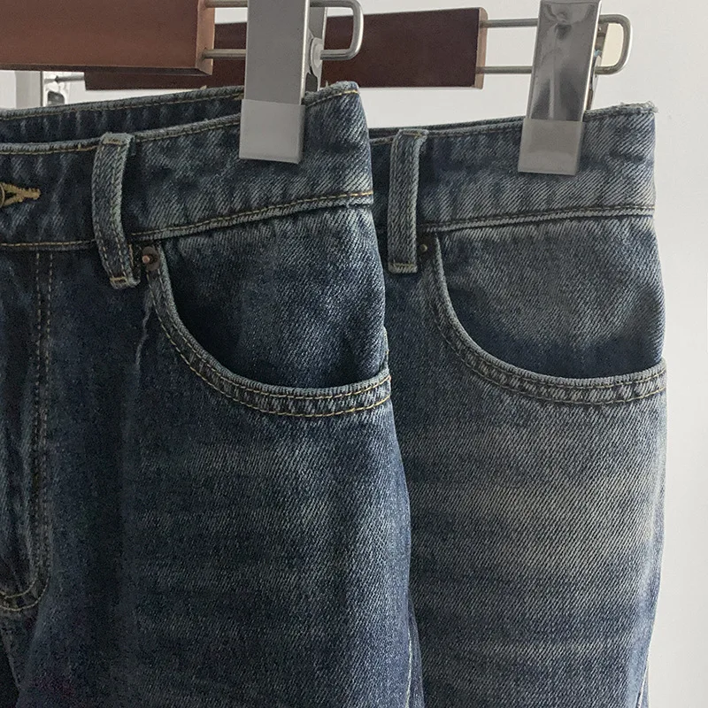 Modne jeansy o luźnym kroju z prostymi nogawkami i szerokimi nogawkami, z efektem spranej tkaniny i skręcanymi szwami.