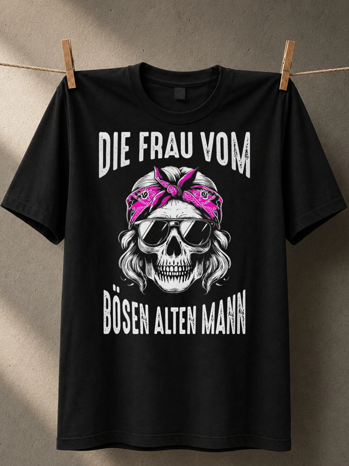 Футболка унисекс с принтом «Biker Wife with German Die Frau Vom text», с изображением женщины с розовыми волосами и в смелом монохромном стиле.