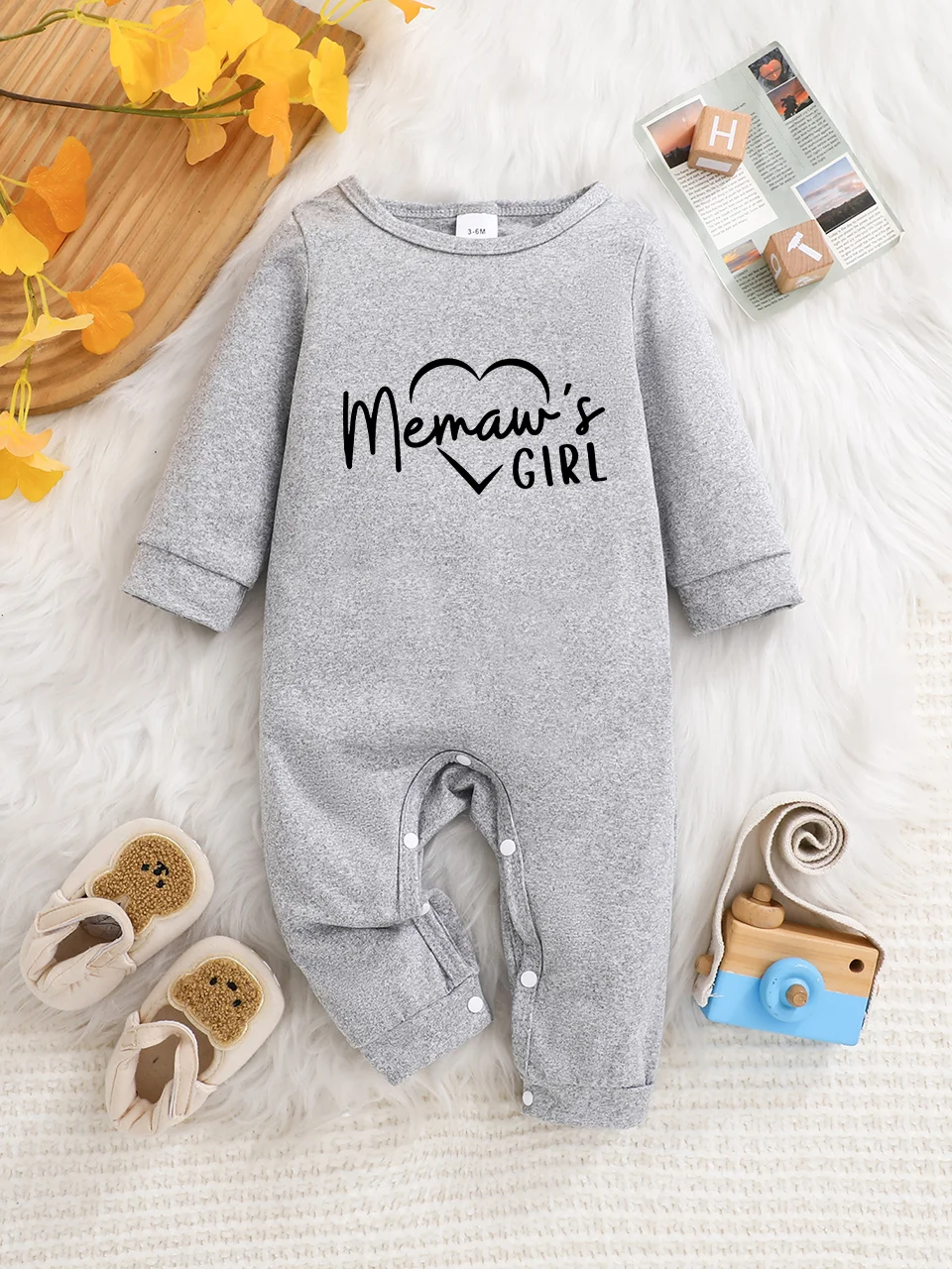 A baby long-sleeved onesie with interesting letter prints. It features a buttoned design for easy putting on and taking off