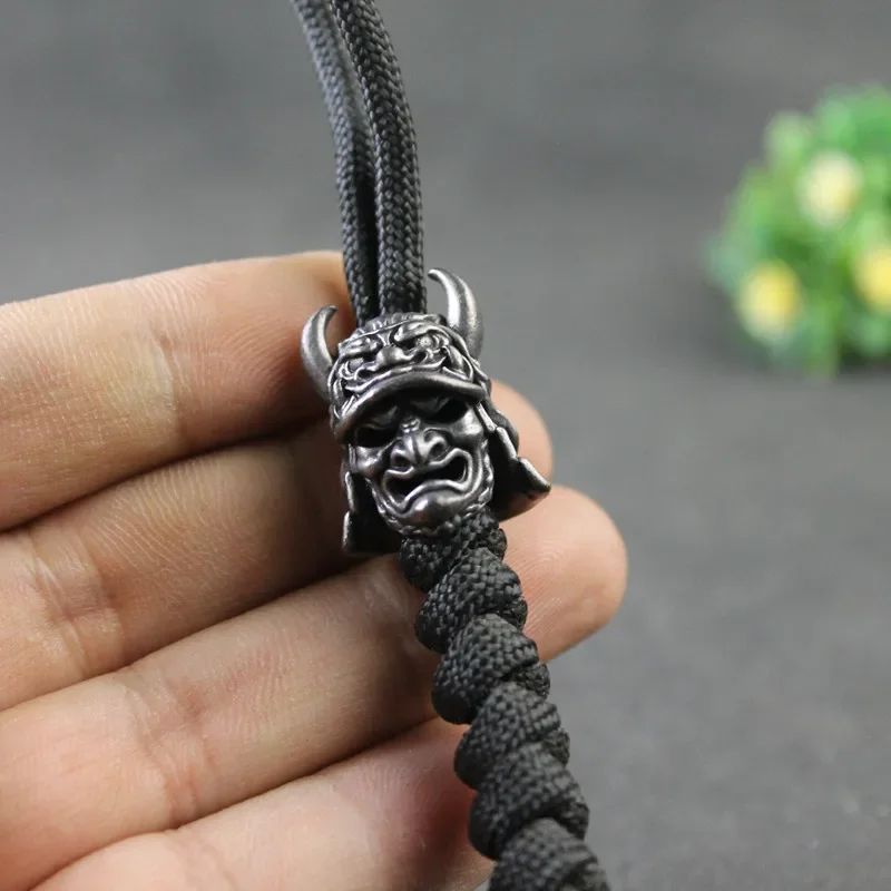 

Black Japanese Eagle Nose Samurai Helmet Bead Brass Woven Paracord Lanyard Pendant Outdoor EDC Umbrella Rope DIY Accessory