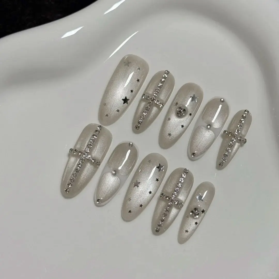 

Silver Cat Eye Press On Nails, Medium Almond Fake Nails with Rhinestone Cross & Star, Shimmer Nude Glue On Nails, Reusable False Nails for Women, Chic Daily Wear