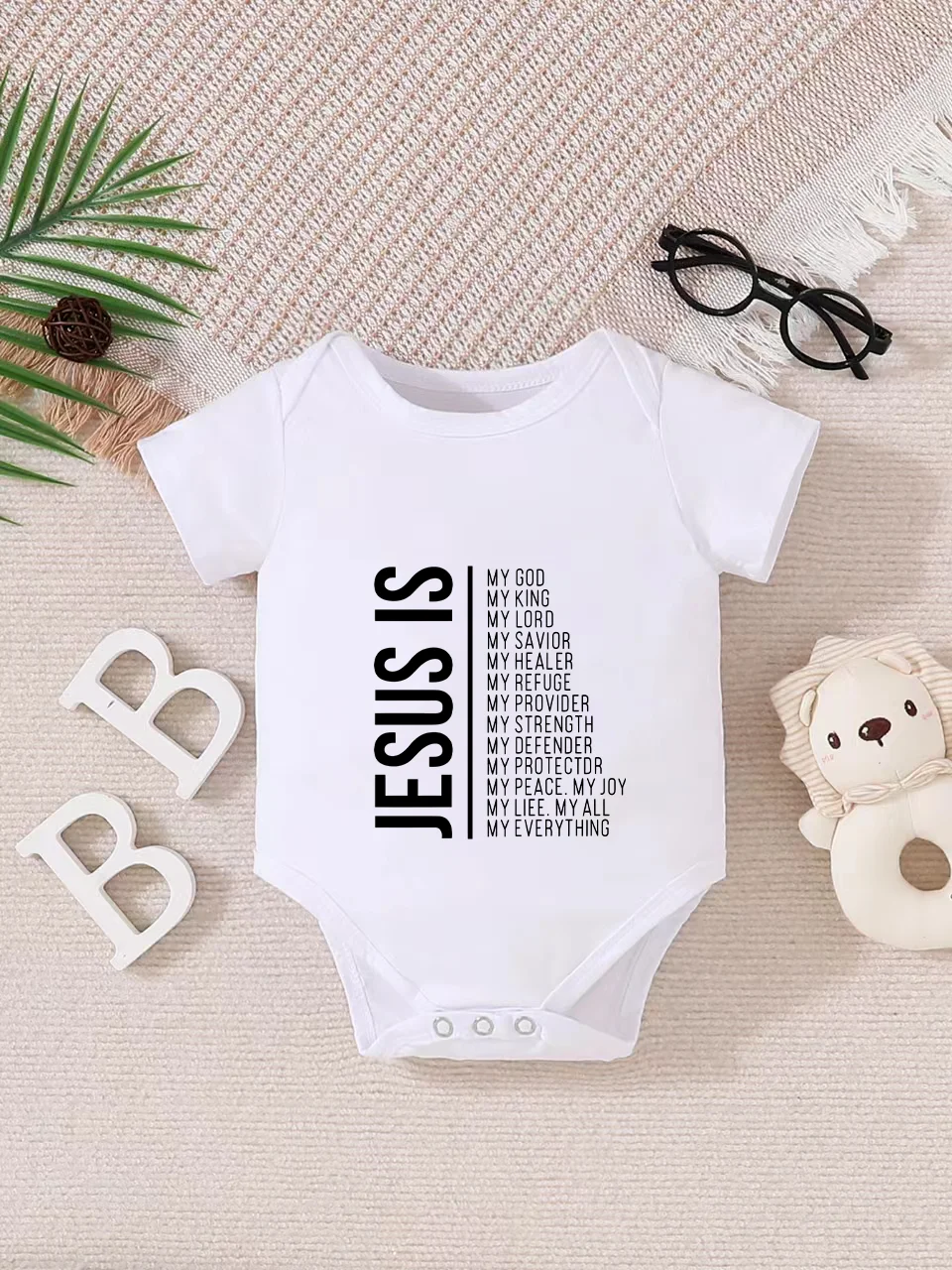 Playful letter-printed baby short-sleeve triangle bodysuit. Button closure for easy dressing, machine washable
