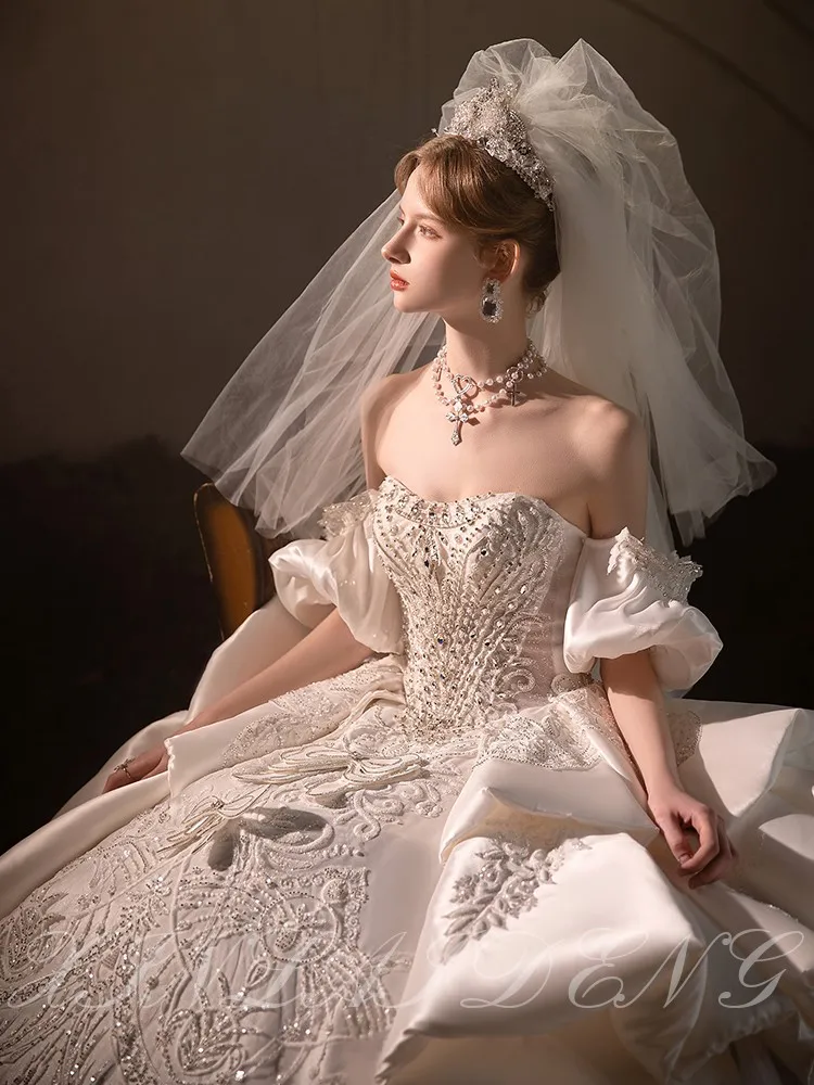 Ein neues, strapazierfähiges One-Shoulder-Kleid aus Satin mit großem Schwanz