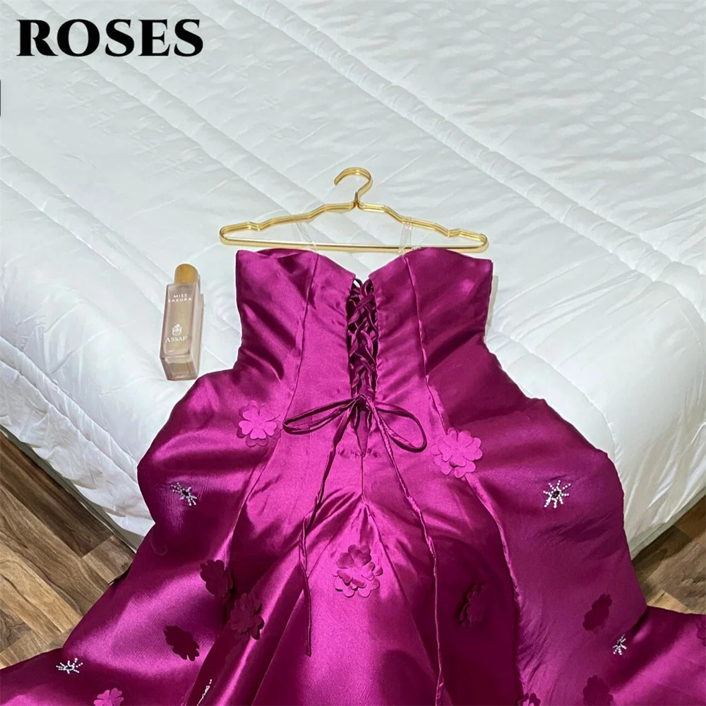 Suknie wieczorowe w kolorze magenta z motywem róż, sukienki na studniówkę z dekoltem w serce, suknie ślubne wieczorowe z aplikacjami kwiatowymi, suknie wieczorowe bez rękawów, suknie balowe na zamówienie.