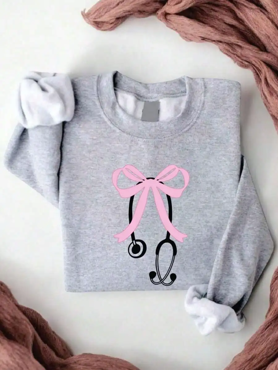 

Серый свитшот с розовым бантом и графикой стетоскопа, повседневный дизайн в стиле медсестринского дела