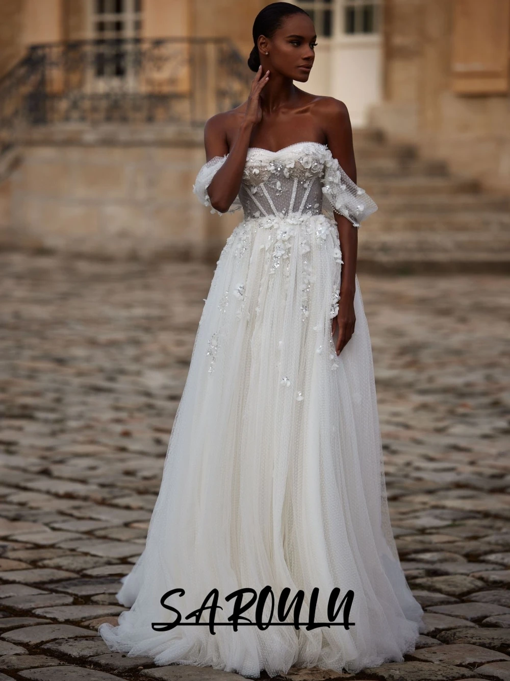 ชุดแต่งงานเจ้าสาวสีขาวหรูหราแบบเปิดไหล่ ผ้าทูลล์ ประดับดอกไม้ 3 มิติ ปักเลื่อม แต่งลูกไม้ผูกด้านหลัง สามารถสั่งตัดได้