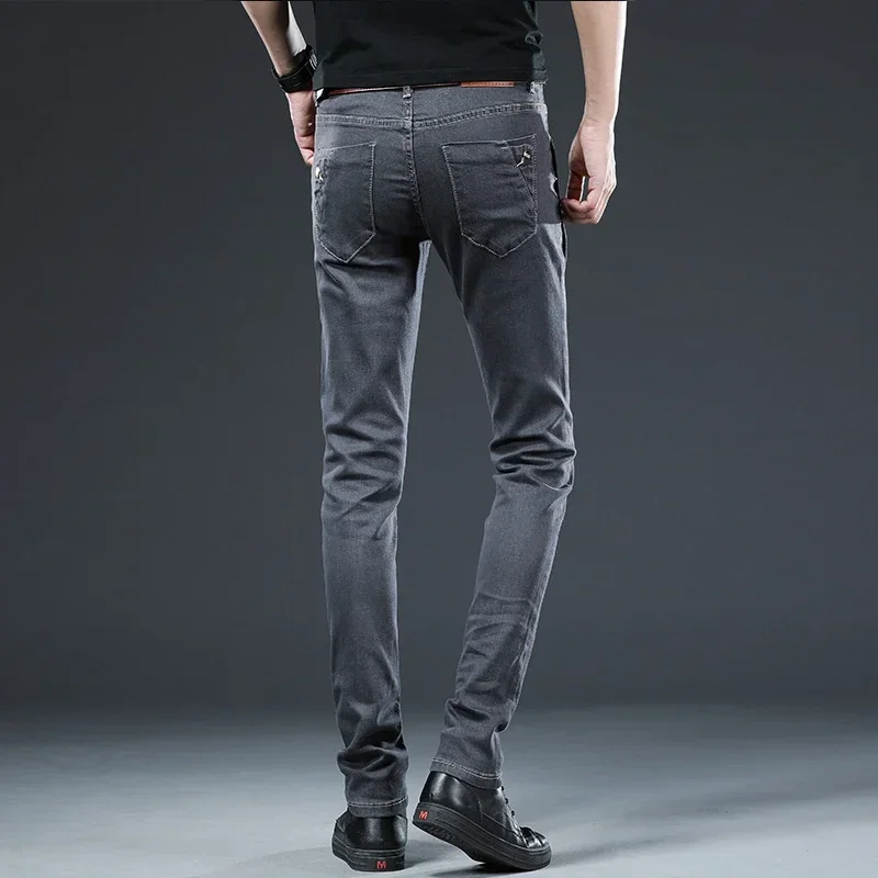 Celana Jeans ramping pria, pakaian Denim abu-abu kaki kecil modis Skinny lurus elastis di Korea
