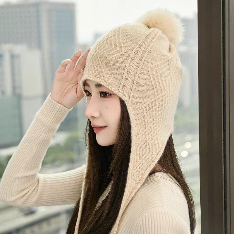 قبعة كرة شعر عصرية للسيدات شتوية سميكة 100% من الكشمير الخالص محبوكة بلون سادة قبعة حماية للأذن دافئة ومقاومة للرياح