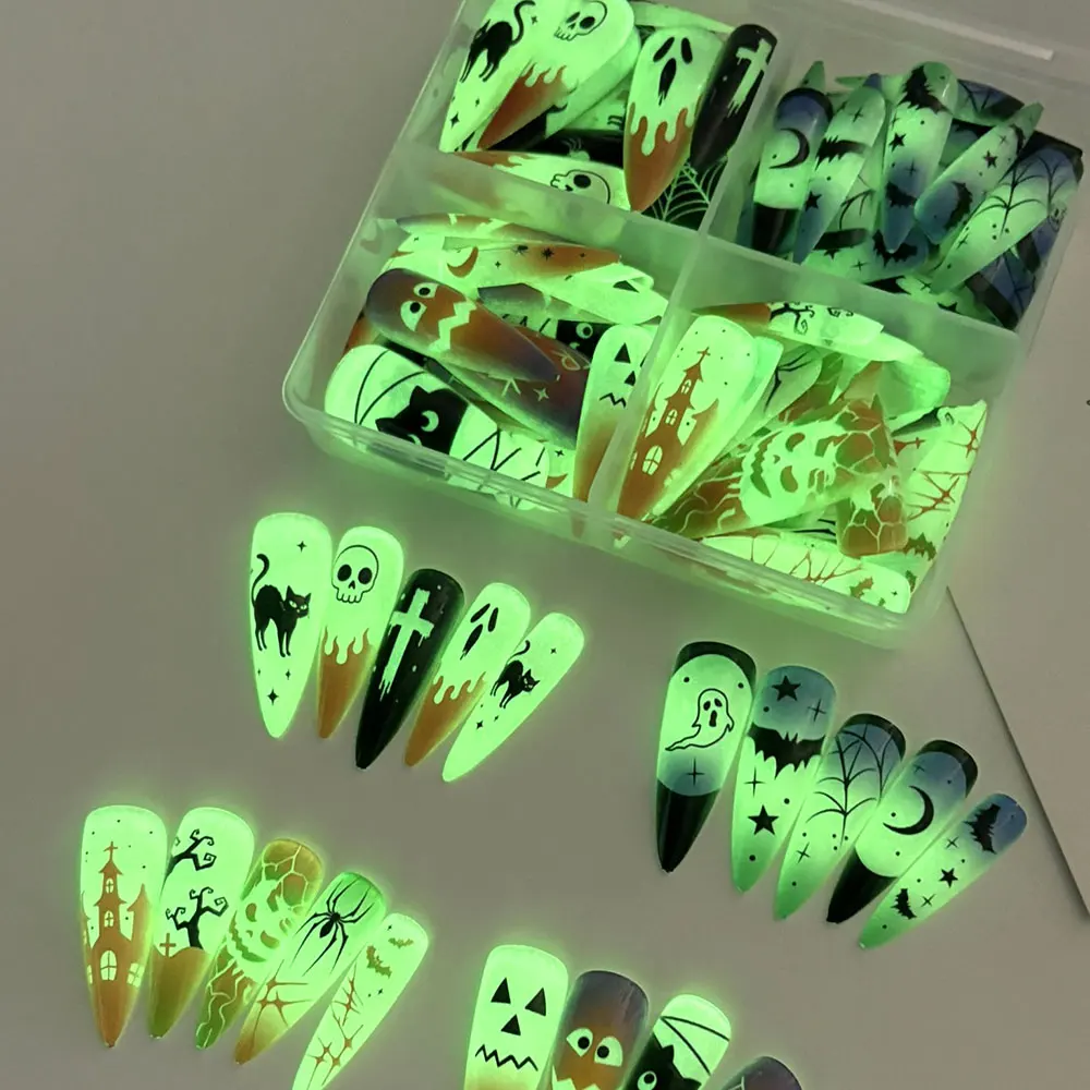 96 Stück leuchtende, im Dunkeln glänzende Halloween-Press-On-Nägel in der Form von langen Mandeln, mit 3D-Motiven wie Geistern, Kürbissen und Kreuzen, sowie Totenköpfen, als vollständige Nagelverlängerung für Partys. – Detail 2