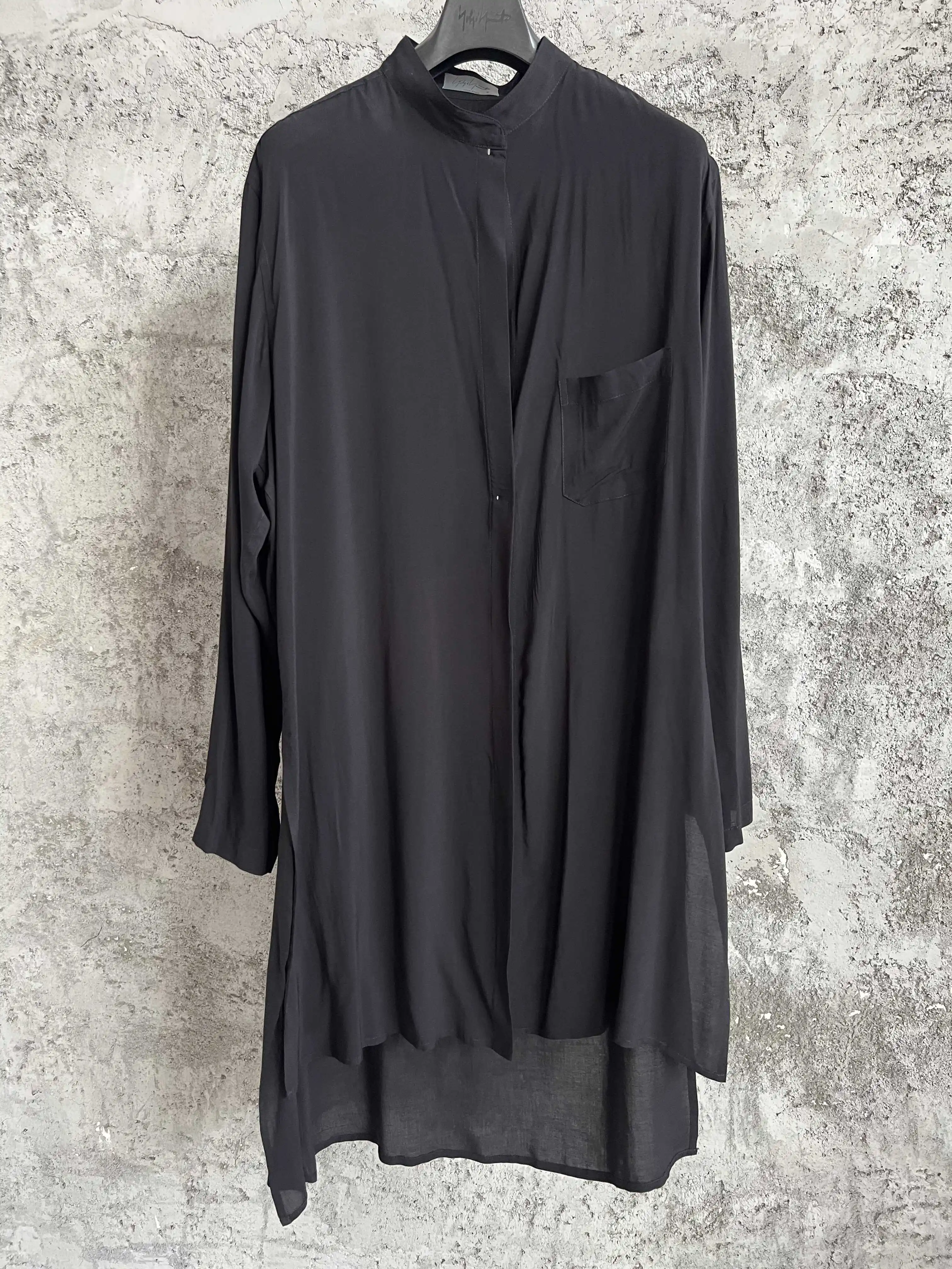 

Designed single-breasted mid-length shirt in black with side slits at the back