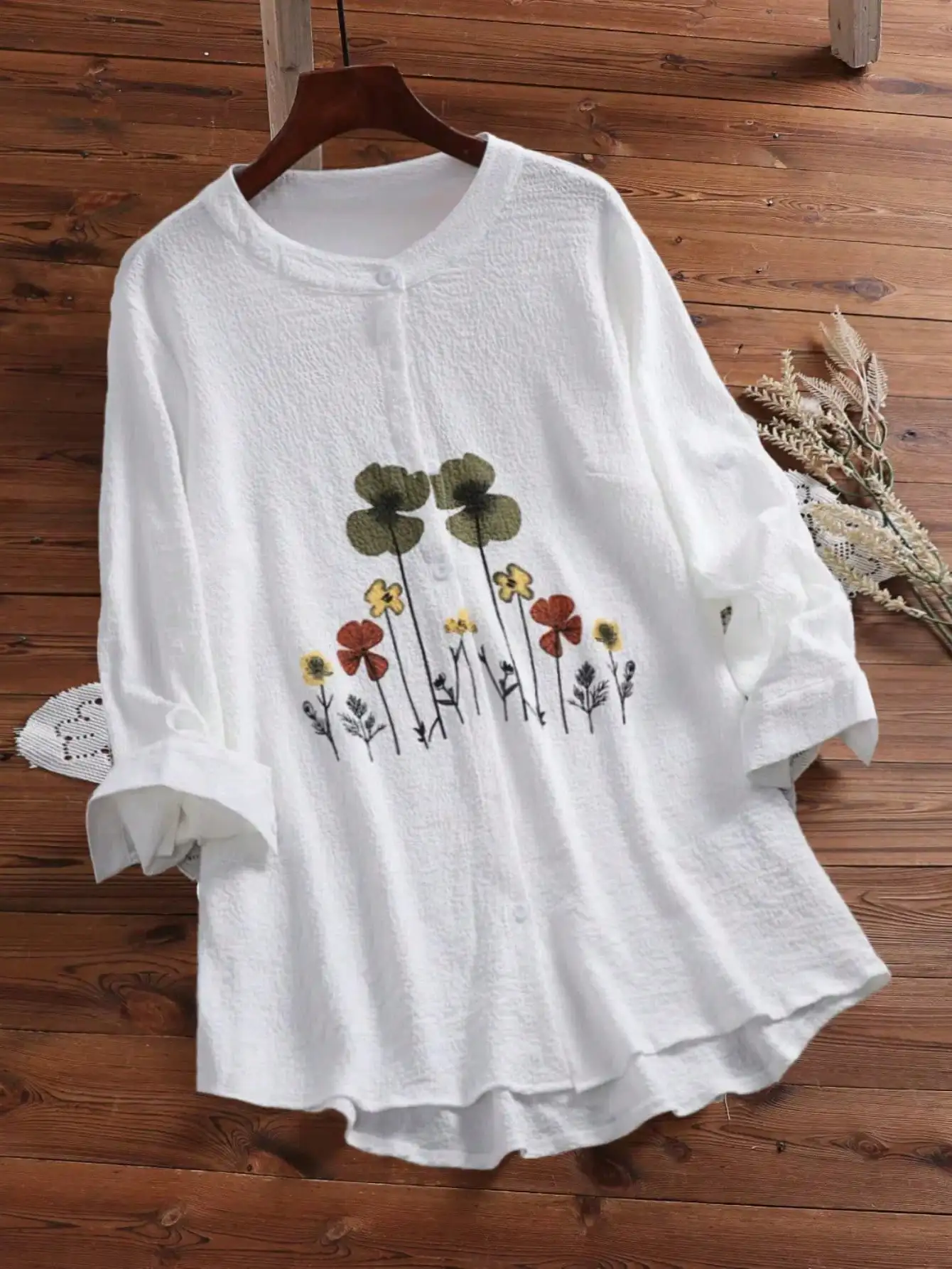 

Женская рубашка больших размеров с цветочным принтом и круглым вырезом.