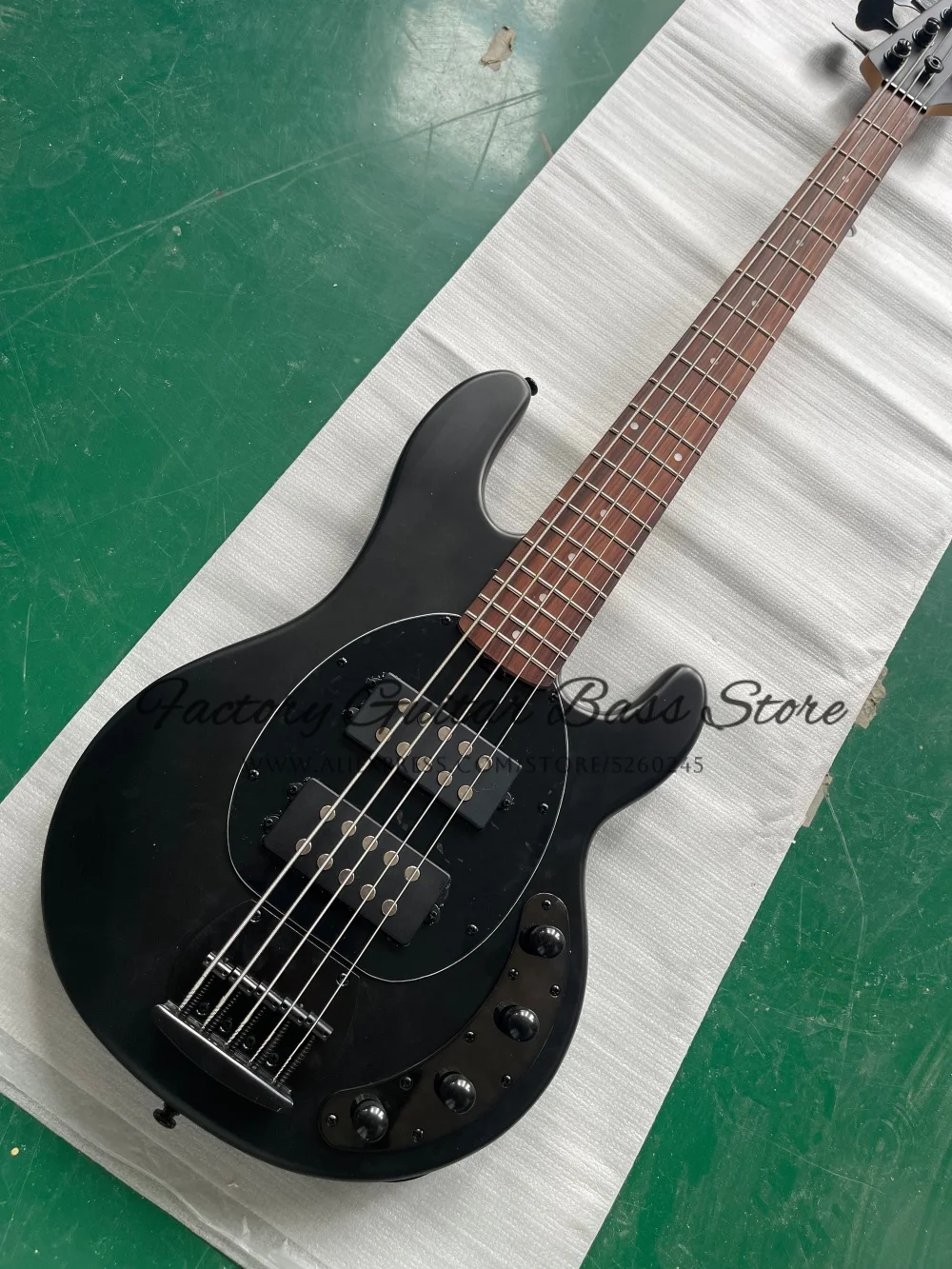 

Изготовленный на заказ 5-струнный матовый черный бас, фиксированный мост, звукосниматель HH, активный аккумулятор, корпус из цельного дерева, кленовый гриф, черный тюнер