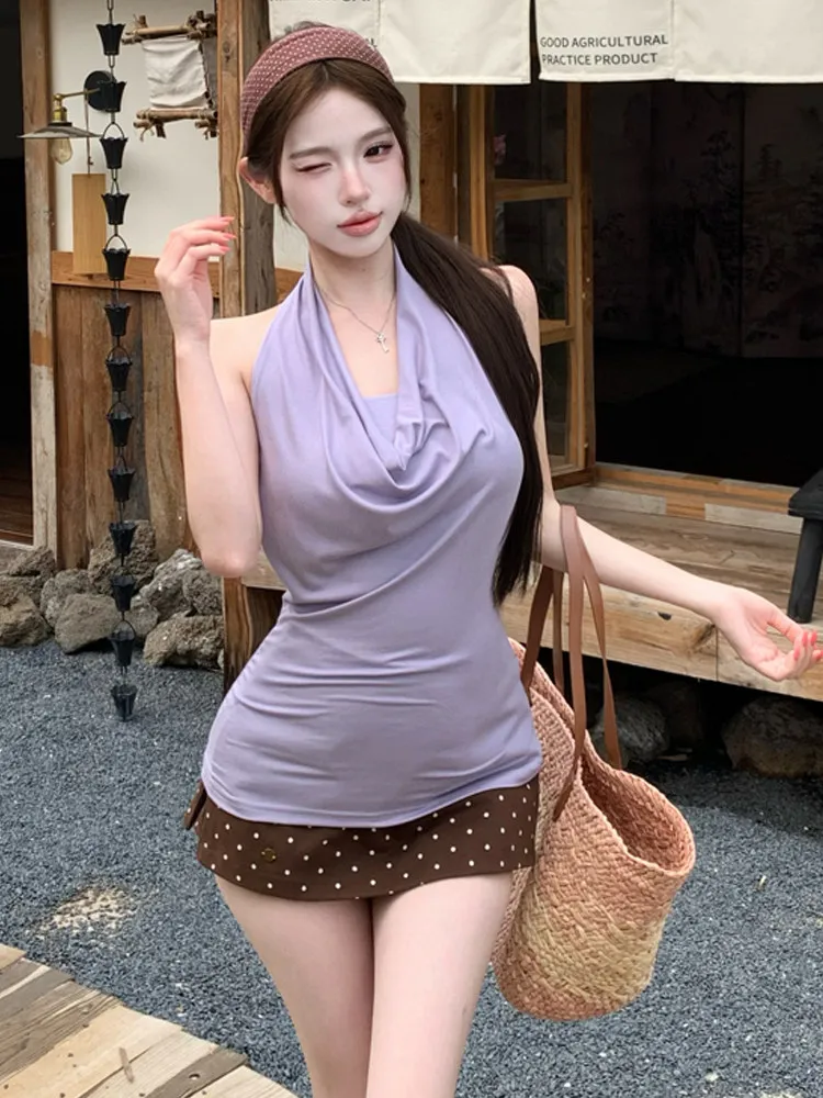 

Сексуальный комплект из двух предметов: топ с открытой спиной и завязками на шее, однотонный, облегающий, и короткая юбка в горошек, облегающая бедра, с принтом.