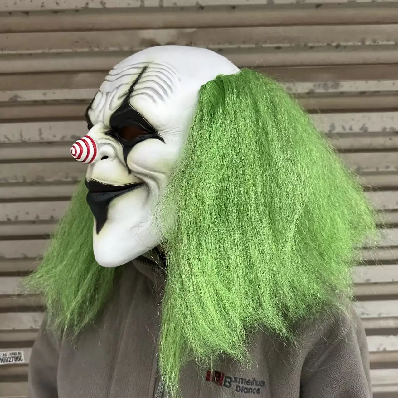 Furchteinflößender grünhaariger Clown mit Latexmaske und einer spiralförmigen rot-weißen Nase. Geeignet für Halloween-Kostümparty-Requisiten – Detail 3