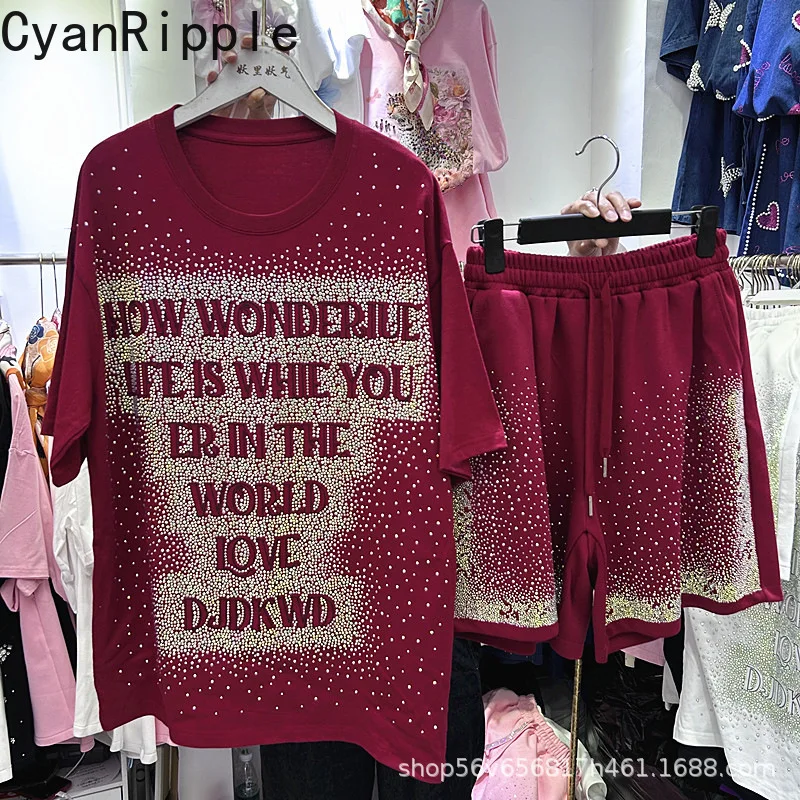 

Модный летний женский комплект из двух предметов: блестящая футболка с надписями и стразами, свободного кроя, с коротким рукавом + повседневные шорты А-силуэта на резинке