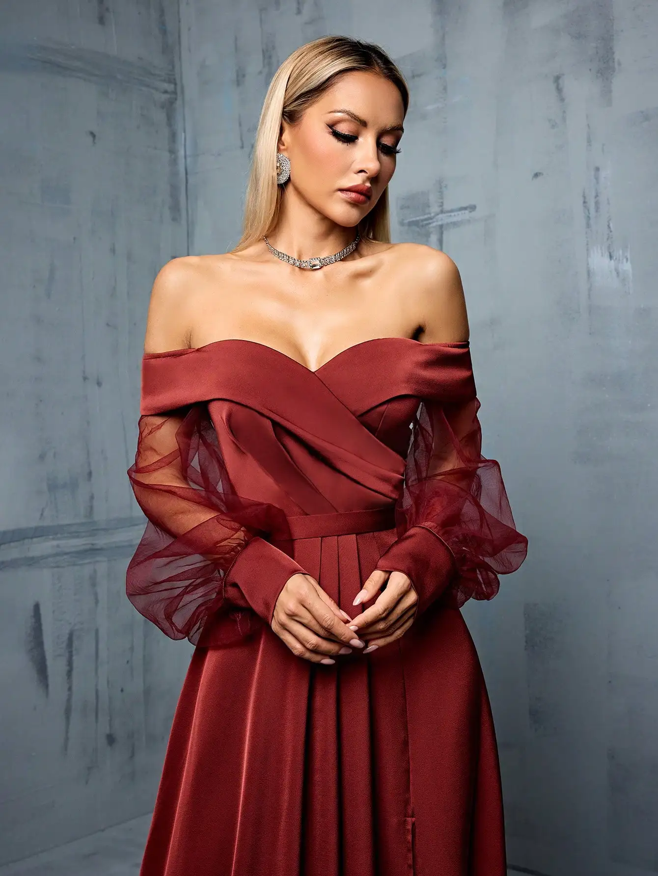 Bridesmaid's floor-length gown with off-shoulder neckline, mesh-satin paneling, and side slit