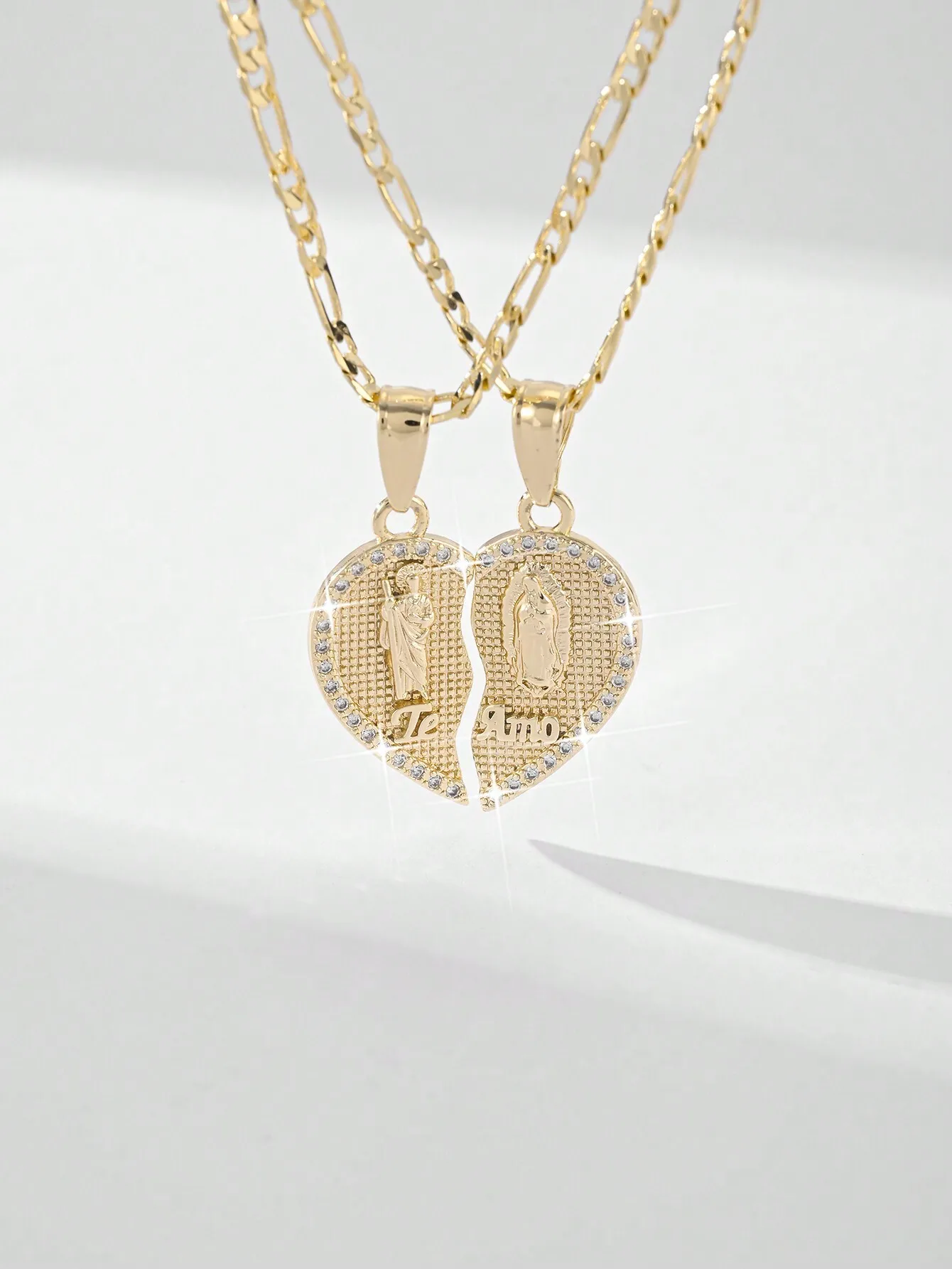 

Золотистое ожерелье с подвеской в виде сердца, гравировкой религиозных фигур и вставками из циркония