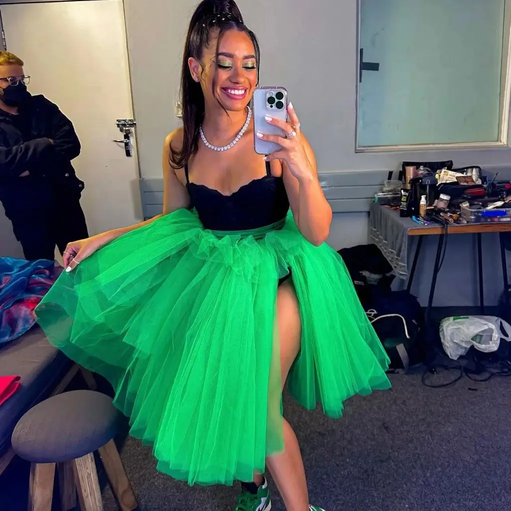 Green Tulle Skirt With Layers And Side Slit Worn By Woman Sitting On Stool In Backstage Area With Makeup Table Nearby Customize