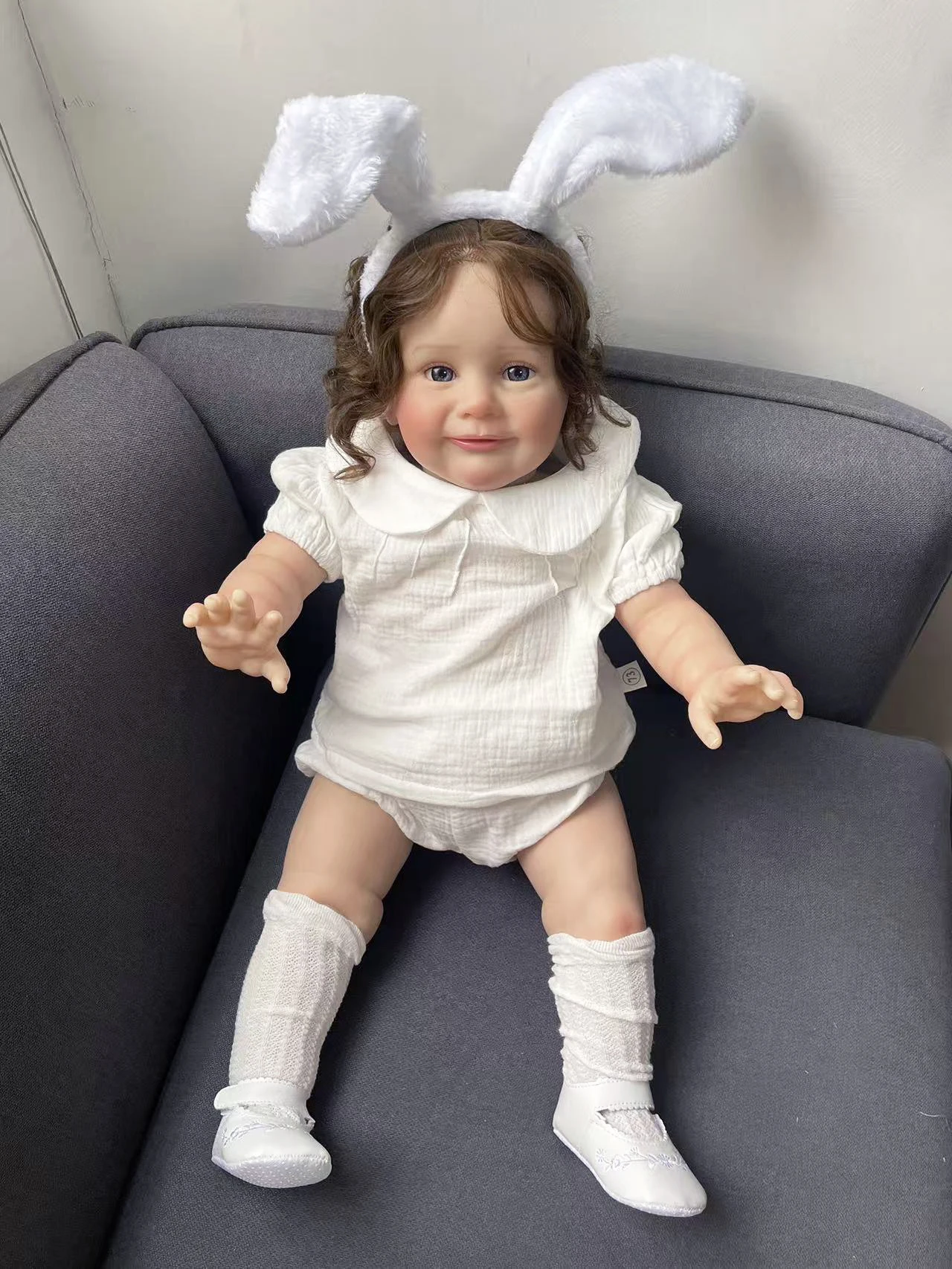 25Inch Hand Root Hair Zoe Wearing A White Short Sleeved Clothing Set and White Rabbit Ear Headband Lifelike Cute Reborn Doll