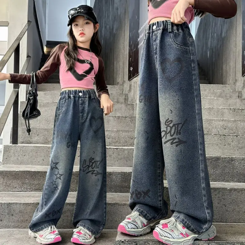 The wide leg jeans for girls are designed with graffiti patterns, showcasing a deep street chic style while maintaining a slim a