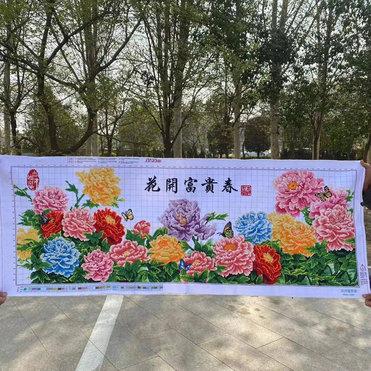 

Готовое изделие ручной работы: вышивка крестиком с искусственным цветочным узором, изображающим пионы, символизирующими богатство и процветание.