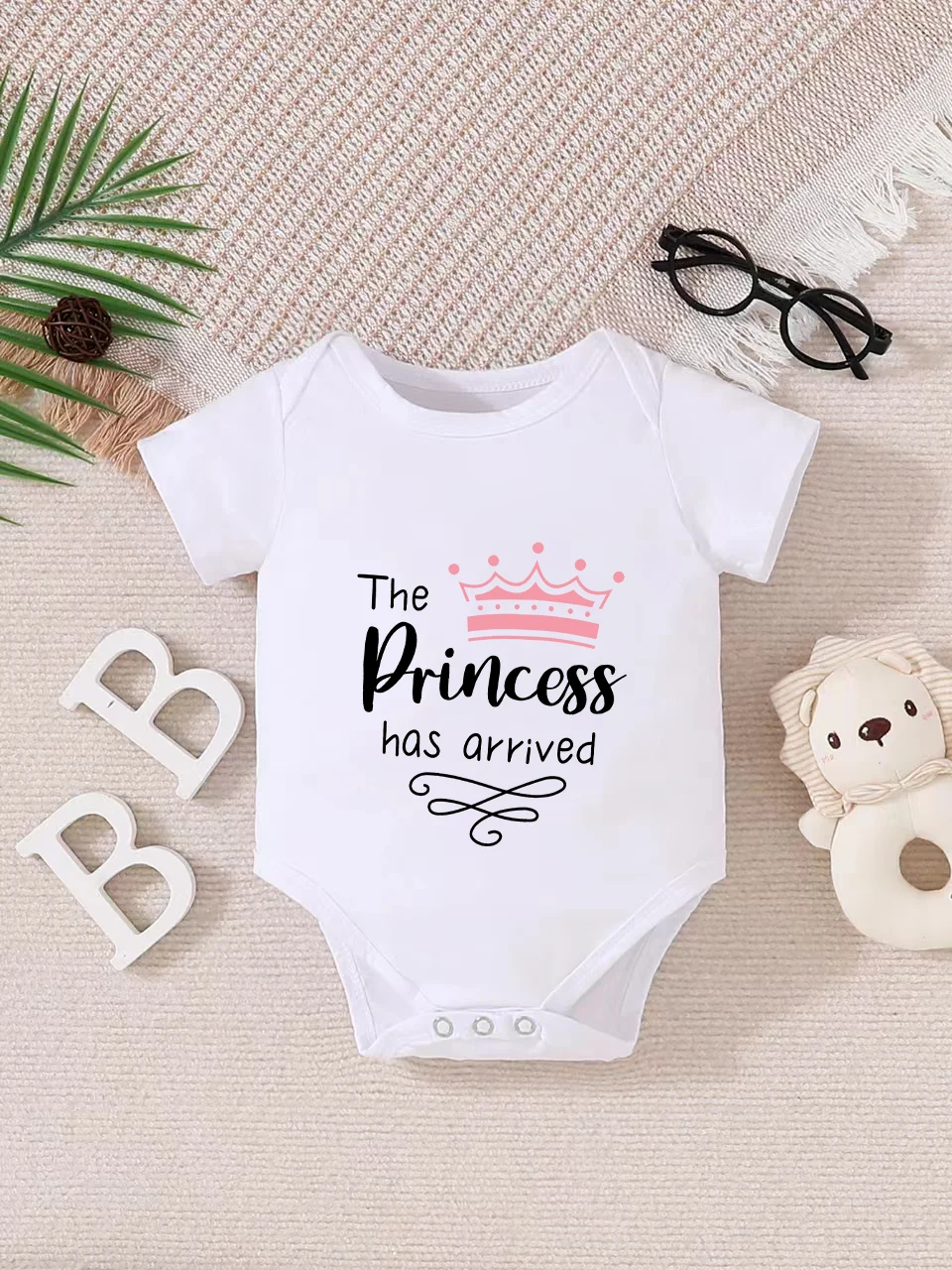 Playful letter-printed baby short-sleeve triangle bodysuit. Button closure for easy dressing, machine washable