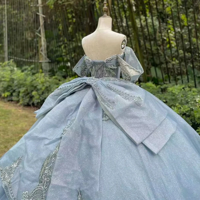 فساتين Quinceanera باللون الأزرق الفاتح اللامع ثوب حفلة قبالة الكتف مزين بالدانتيل مطرز بفيونكة مشد متدرج تول حفلة عيد ميلاد سوي