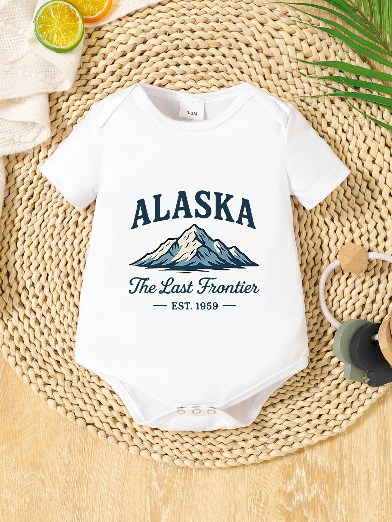 The Baby Onesie Is Printed with Dark Blue 'alaska' Letters and A Snow Mountain Pattern, Easy and Attractive  for Outdoor