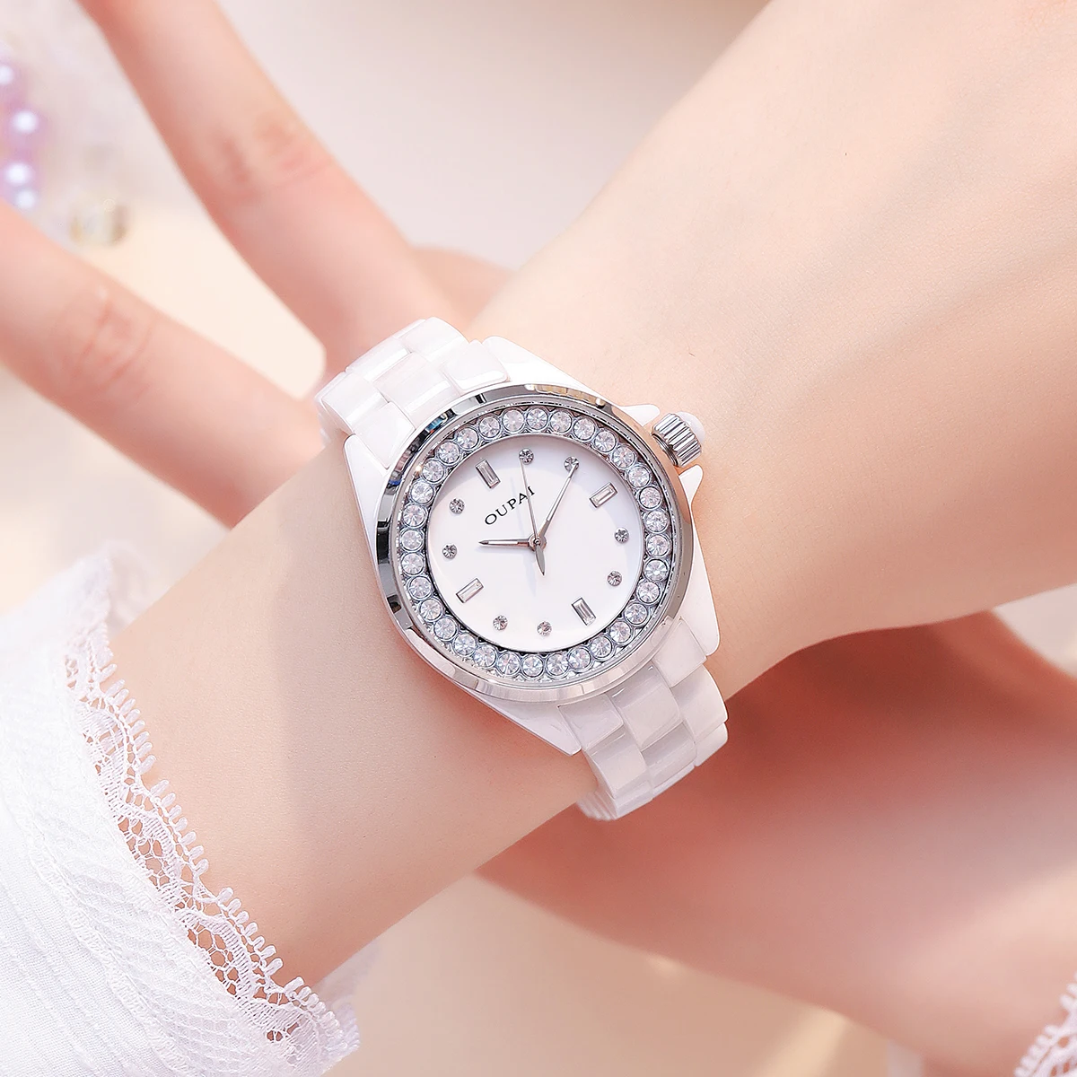 ساعة يد نسائية دائرية من Oupai ساعة سيراميك بيضاء بمقياس حجر الراين كوارتز تتحرك ساعة نسائية أنيقة وعصرية
