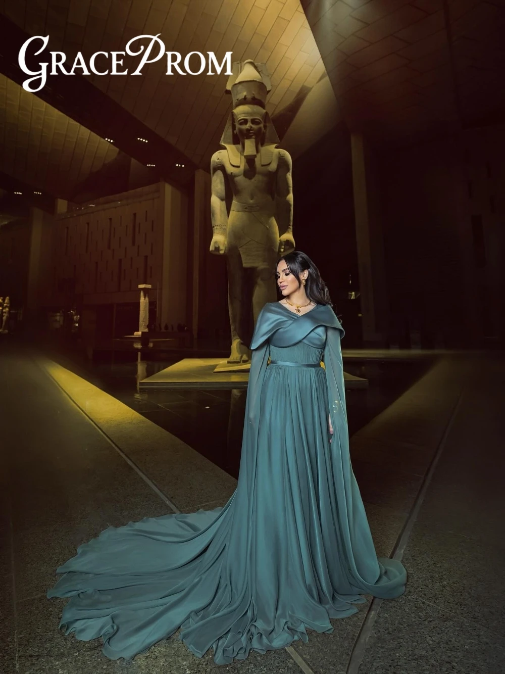 ชุดราตรีสไตล์อียิปต์โบราณสีเขียวอมฟ้า แขนเคป จับจีบ สง่างาม แบบอาหรับ พร้อมชายกระโปรงยาวแบบดราม่า สามารถสั่งตัดได้