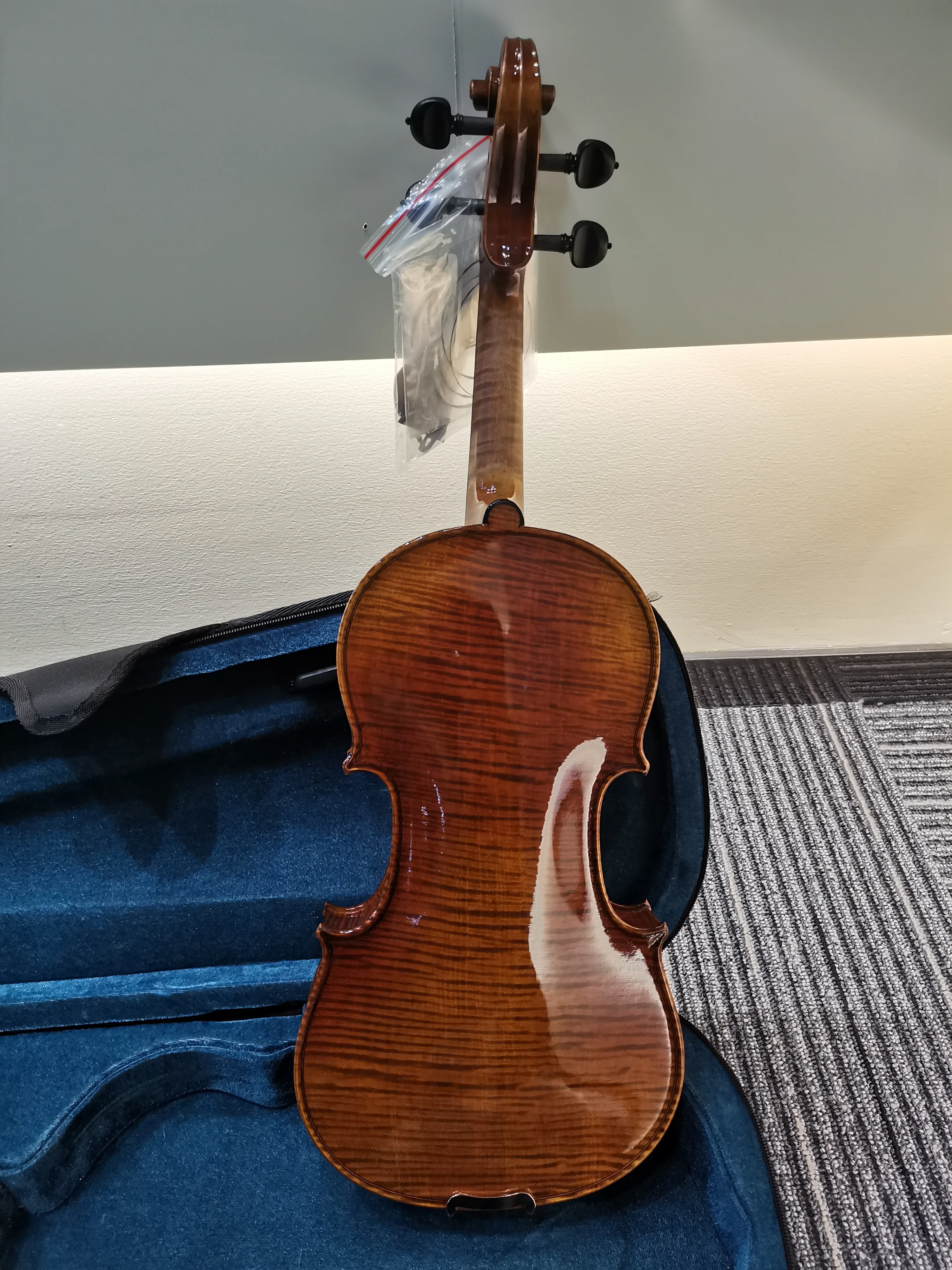 

NEW-4/4 high-end handmade Italian violin with ebony flat knobs and vintage lacquer, featuring strings, bow, and case.