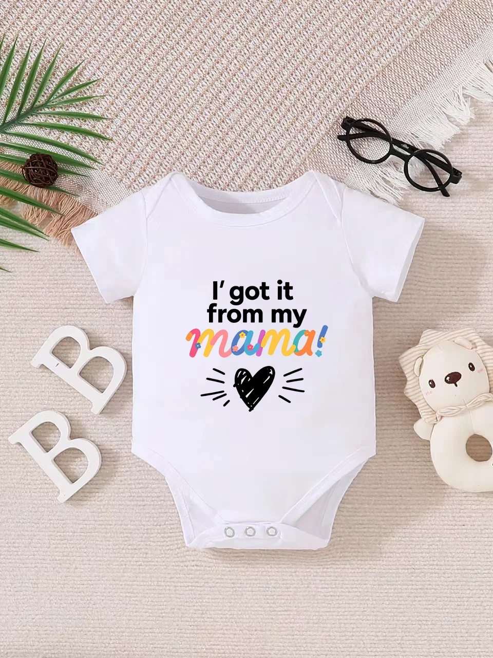 Playful letter-printed baby short-sleeve triangle bodysuit. Button closure for easy dressing