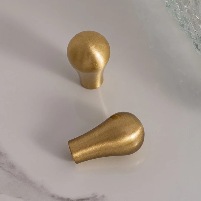 Brushed brass cupboard pull and teardrop knob shown in the supplier product illustration 22