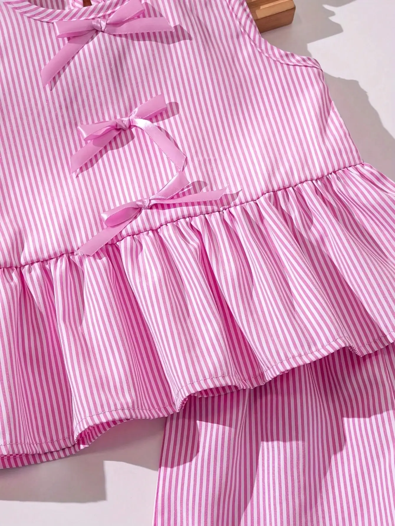 Modisches zweiteiliges Set für Mädchen: rosa-weiß gestreifter Rundhalspullover mit Schnürung, Schleife und Rüschenrand + rosa gestreifte Schmetterlings-Shorts. – Detail 10