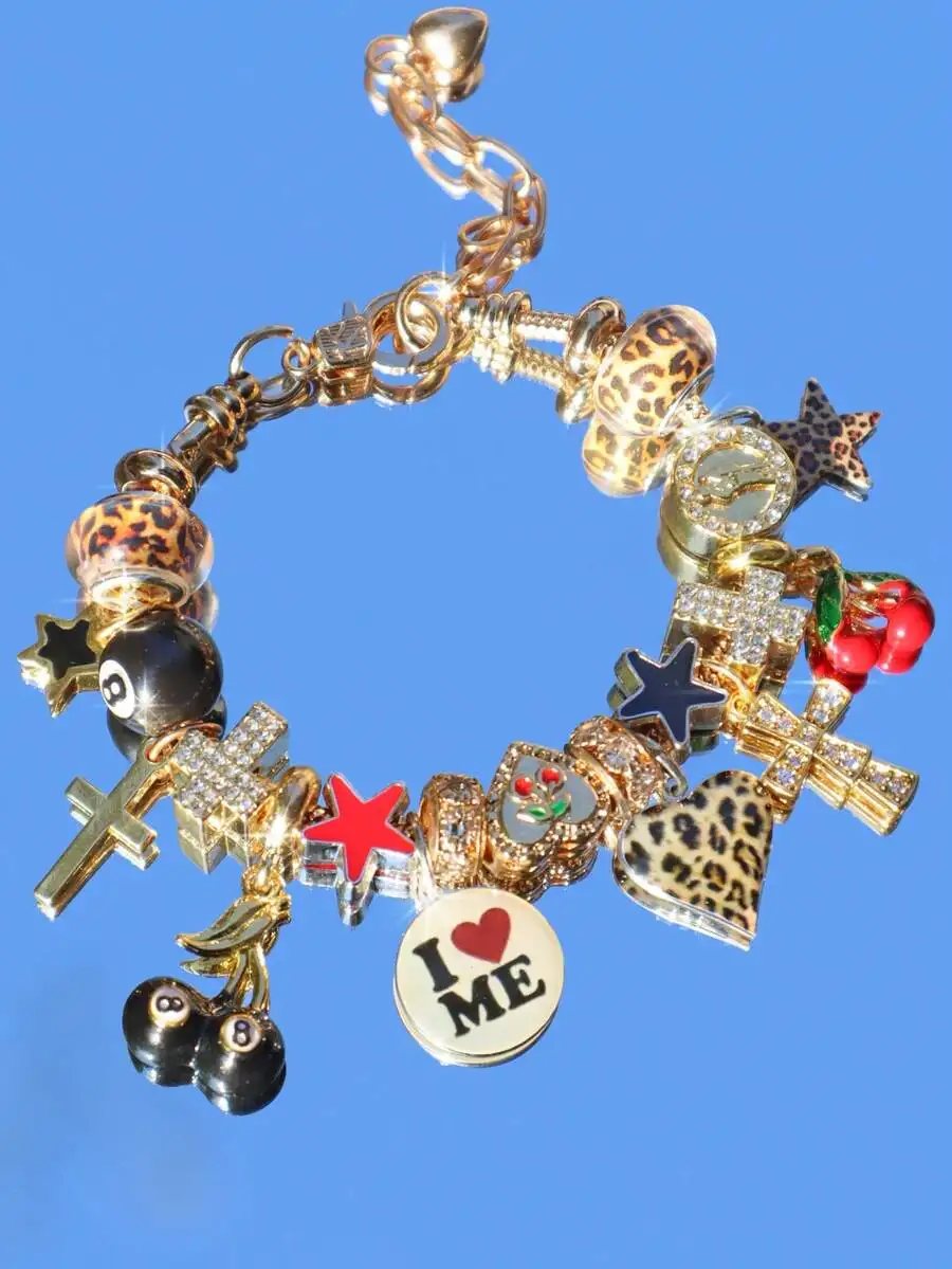 

Браслет с золотистыми подвесками в виде леопарда, звезды, креста и вишни