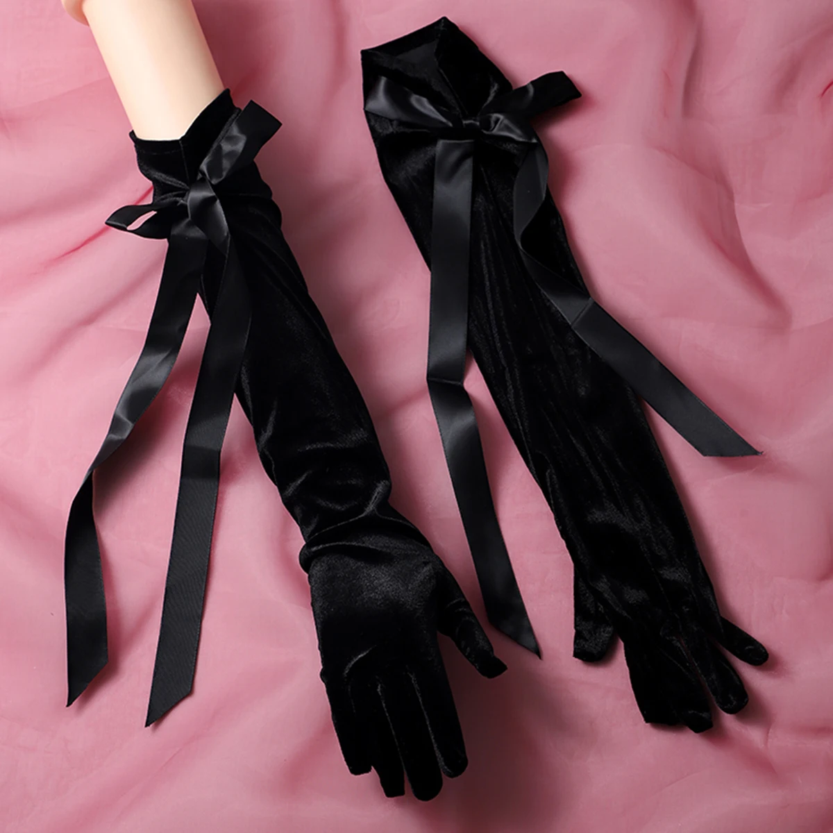 A pair of black gloves with ribbon embellishments in a finger style and elbow length, suitable as accessories for bride weddings