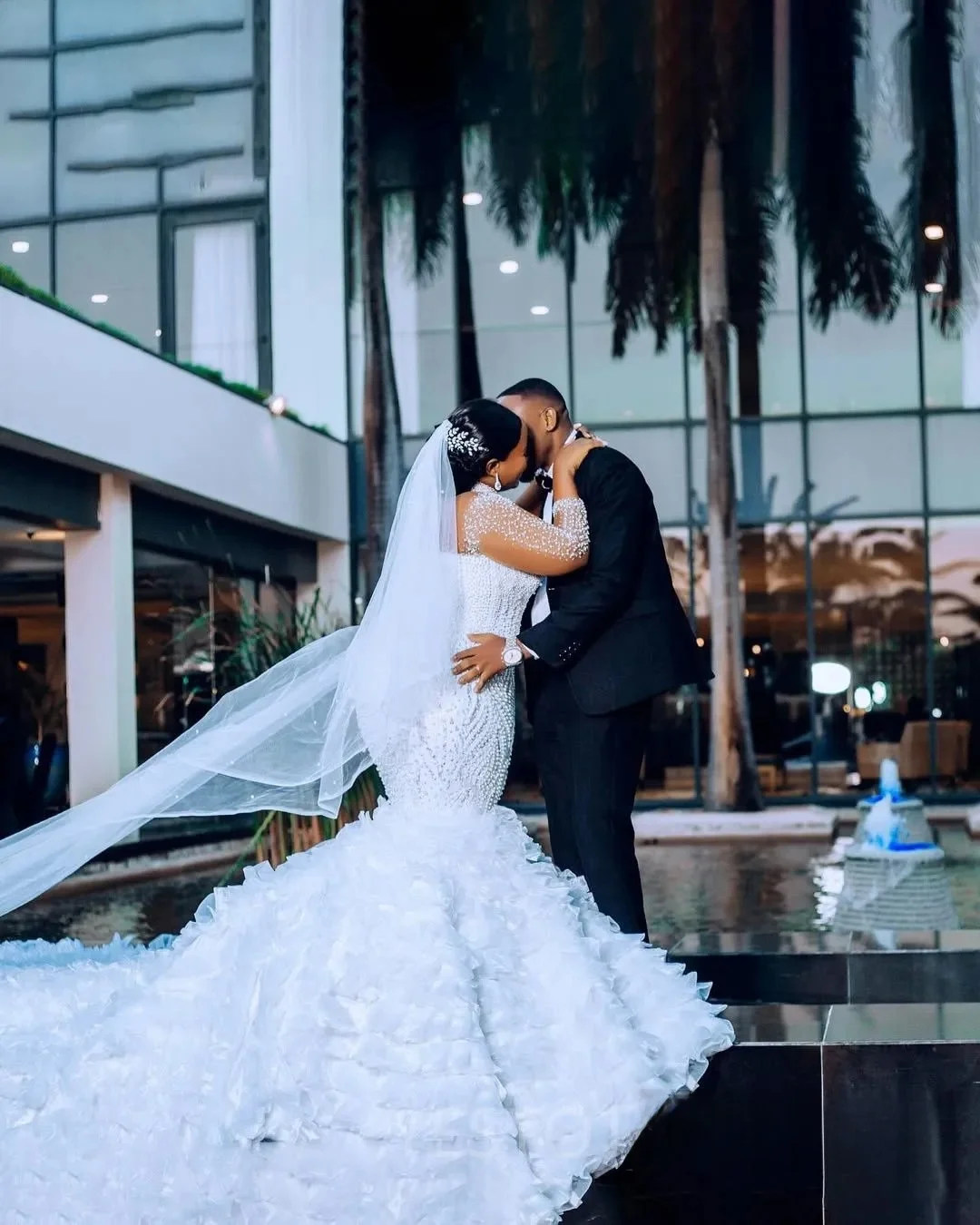 Suknia ślubna na zamówienie, biała, afrykańska, dla panny młodej, krój syreny, długie rękawy, zdobiona perłami i koralikami.