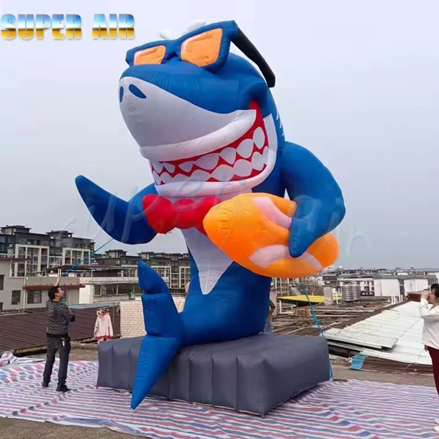 Hermoso modelo de organismo marino, sonrisa, tiburón inflable, sostiene el tobogán y observación de gafas de sol a la venta