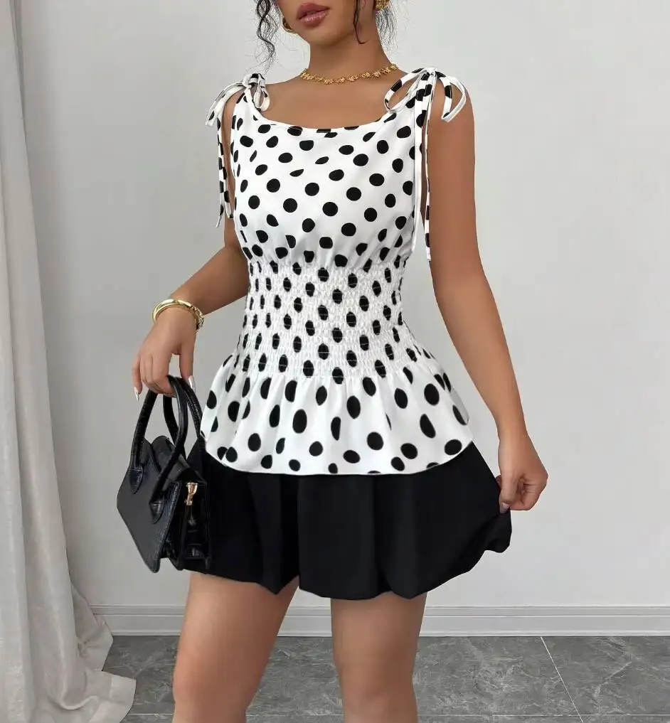 

Женский комплект из двух предметов в горошек: топ с завязками на плечах, присборенной талией и оборками по низу, черная мини-юбка. Милый повседневный наряд для весны и лета.