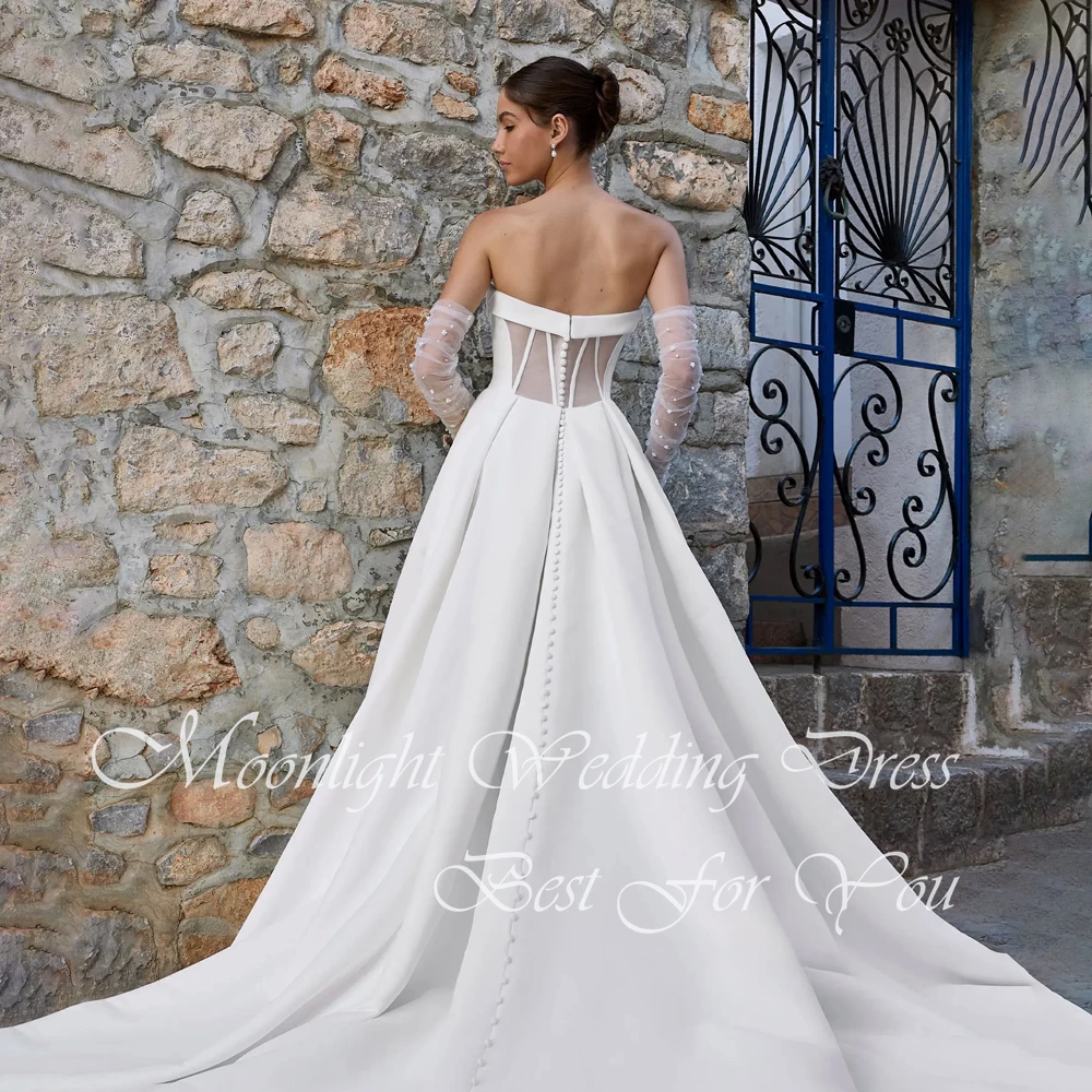 Klasyczna suknia ślubna w kształcie litery A z plisami, dekoltem w serduszko, wysokim rozcięciem z boku, odkrytymi ramionami, odkrytymi plecami, trenem zamiatającym i możliwością personalizacji.